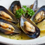 Leckere Muscheln in einer aromatischen Knoblauch-Weißwein-Soße, zubereitet im Airfryer.