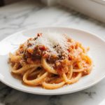 Pasta mit cremiger Tomatensauce aus der Heißluftfritteuse auf einem Teller serviert.