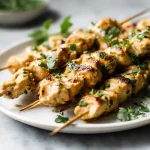 Leckere proteinreiche Erdnuss-Hähnchen-Spieße im Airfryer zubereitet.