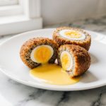 Leckere Schottische Eier aus der Heißluftfritteuse, perfekt knusprig und saftig.